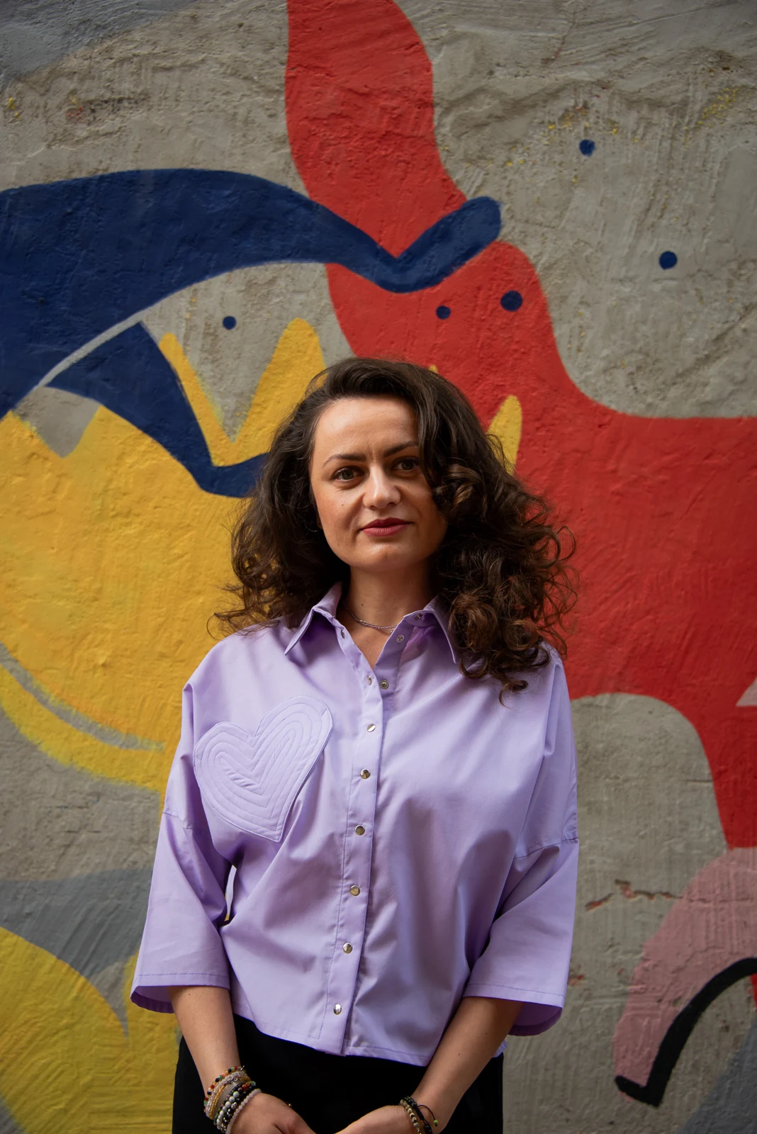 Alina in front of a colourful mural
